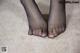 A pair of black stockings on a carpeted floor.