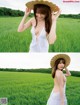 A woman in a white dress and a straw hat in a field.