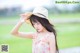 A woman wearing a straw hat standing in a field.