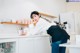 A woman leaning on a counter in a kitchen.