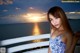 A woman in a blue and white dress standing on a balcony.