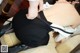 A woman in a black skirt and high heels is putting on her shoes.