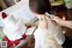 A woman is putting a flower on a wedding cake.