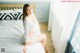 A woman sitting on a bed in a bedroom.