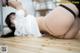 A woman in a white shirt and black stockings laying on the floor.