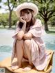 A woman in a pink dress and hat sitting on a yellow chair.