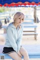 A woman sitting on top of a blue bench.