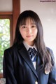 A young woman in a school uniform posing for a picture.